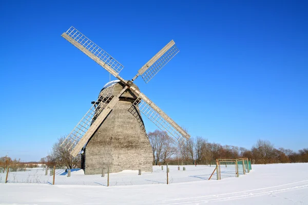 Veroudering windmolen op winter veld — Stockfoto