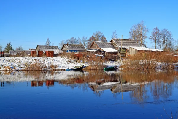 Båtar nära byar vid kusten river — Stockfoto