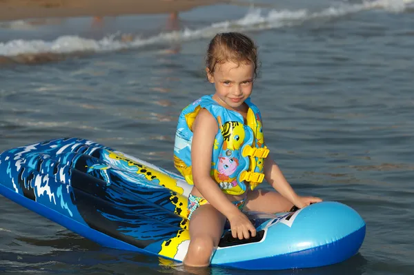 Παιδί σε ένα φουσκωτό στρώμα στη θάλασσα在海中充气床垫上的孩子. — 图库照片