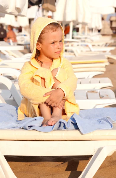 Kind in een badjas op tapijt. — Stockfoto