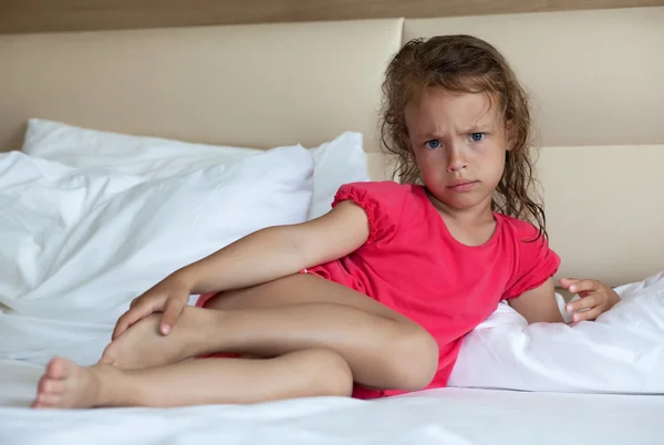 Wütendes kleines Mädchen auf dem Bett liegend. — Stockfoto