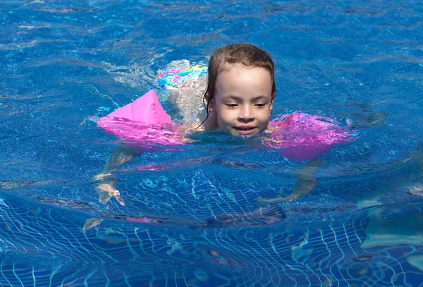 Radosna dziewczynka pływanie w basenie. — Zdjęcie stockowe