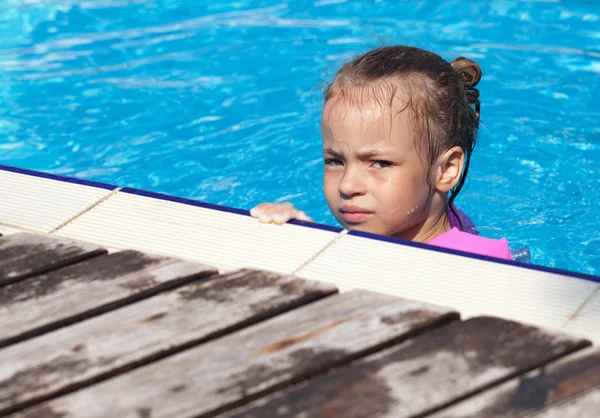 Petite fille bouleversée nageant dans la piscine . — Photo