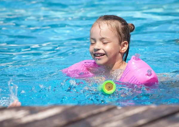Радостная маленькая девочка плавает в бассейне . — стоковое фото