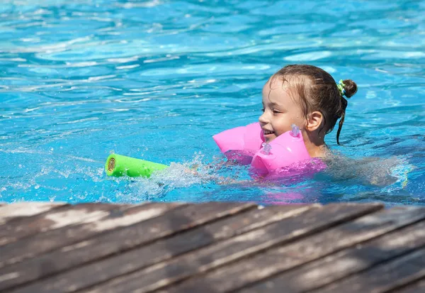Radosna dziewczynka pływanie w basenie. — Zdjęcie stockowe