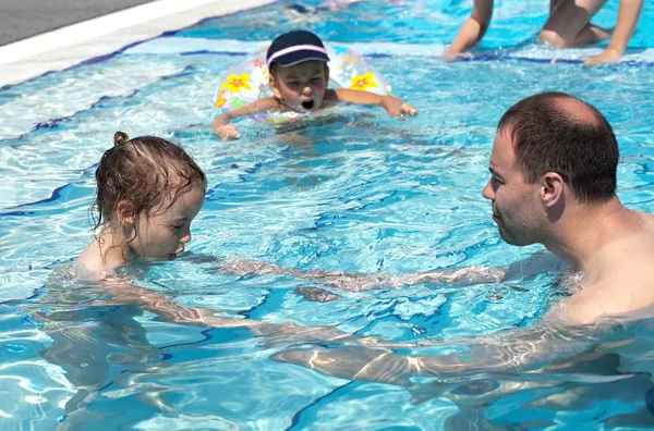 Papa bringt seiner Tochter das Schwimmen im Pool bei. — Stockfoto