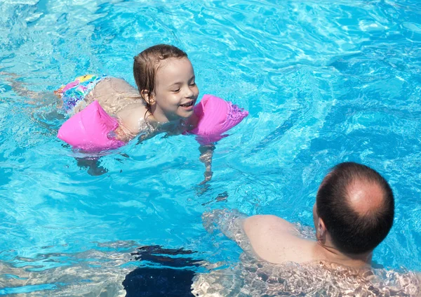 Joyeuse petite fille avec papa dans la piscine — Photo