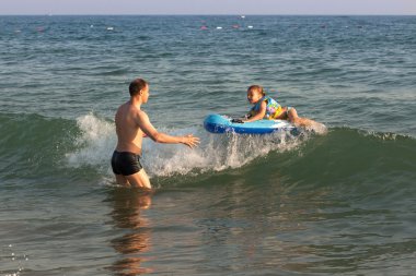 Baba çocuk deniz dalga sürme yakalar.