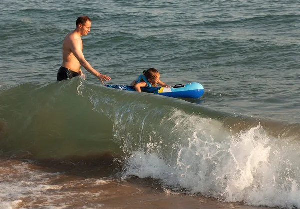 老爸抓到孩子骑着海中的波浪. — 图库照片