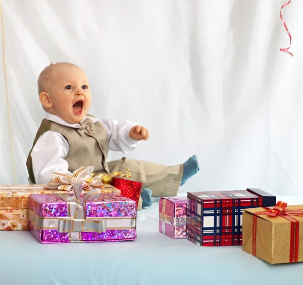 Um bebé de um ano com prendas. Dia de nascimento . — Fotografia de Stock