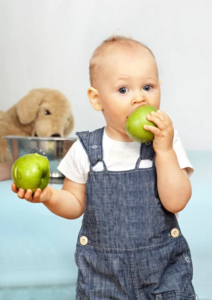 Ett år gamla barn äter ett grönt äpple. — Stockfoto