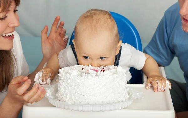 O miúdo come bolo. Família celebra o primeiro aniversário de seu filho . — Fotografia de Stock