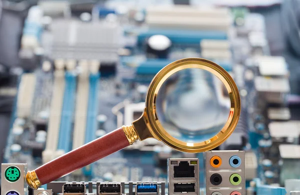 Magnifying glass and circuit board — Stock Photo, Image