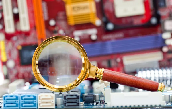 Magnifying glass and circuit board — Stock Photo, Image