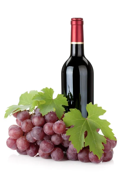 Красная бутылка вина и виноград — стоковое фото