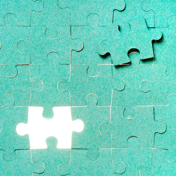 Hand inserting missing piece of green jigsaw puzzle into the hol — Stock Photo, Image