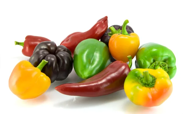 Červené, zelené a žluté papriky na bílém pozadí — Stock fotografie