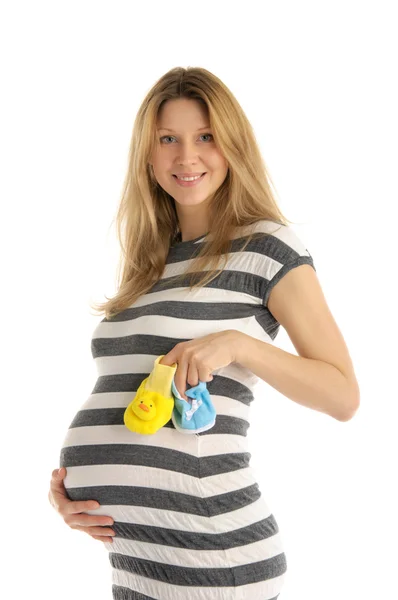 Беременная женщина держит детские туфли — стоковое фото