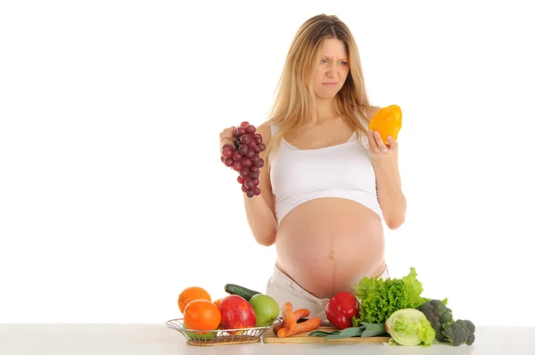 Mujer embarazada infeliz con frutas y verduras — Foto de Stock