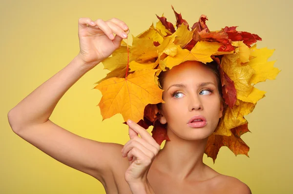 Hermosa mujer con hojas de otoño en amarillo — Foto de Stock