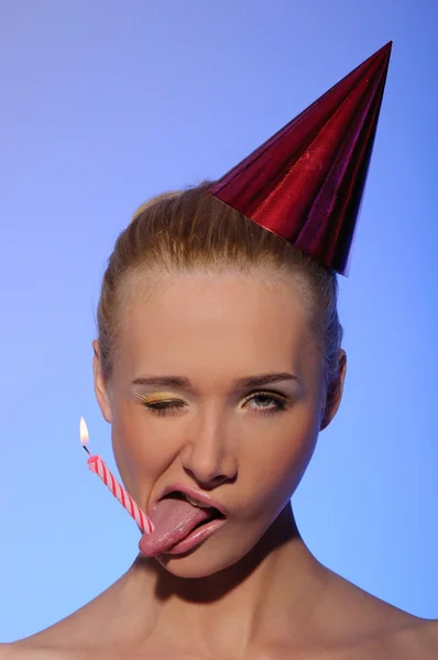 Γυναίκα με κερί σε εορταστική καπέλο tongueand — Φωτογραφία Αρχείου