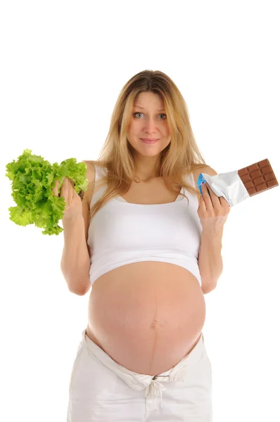Pregnant woman with chocolate and lettuce — Stock Photo, Image