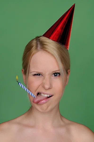 Woman with candle in tongue and festive cap — Stok fotoğraf