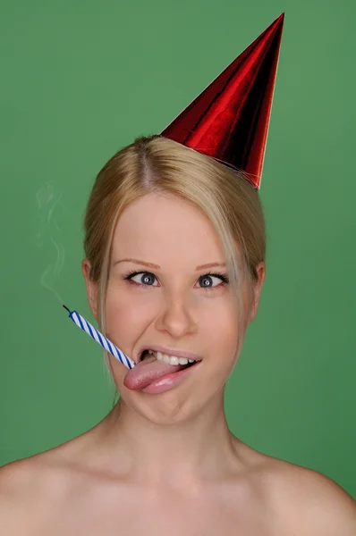 Woman with candle extinguished and festive cap — Stock Photo, Image