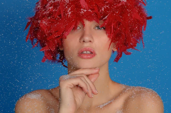 Mujer con plumas rojas en la nieve —  Fotos de Stock