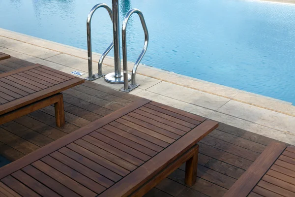 Cadeiras arranjadas ao lado da piscina — Fotografia de Stock