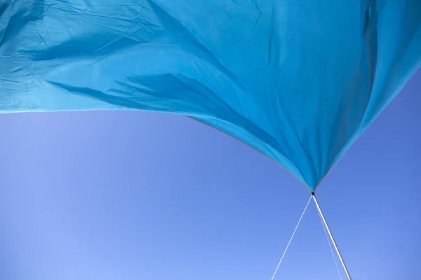 Tienda azul ondeando en el cielo azul —  Fotos de Stock
