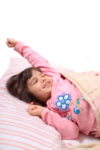 Маленька дівчинка розтягується в ліжку — стокове фото