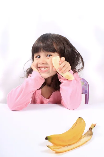 Kislány banánt eszik — Stock Fotó