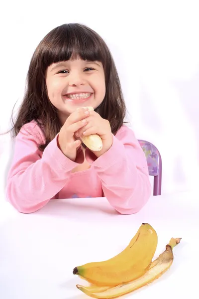 바나나를 먹는 어린 소녀 — 스톡 사진