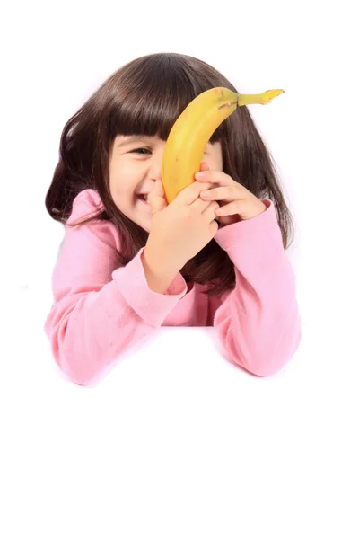 Маленька дівчинка їсть банан — стокове фото