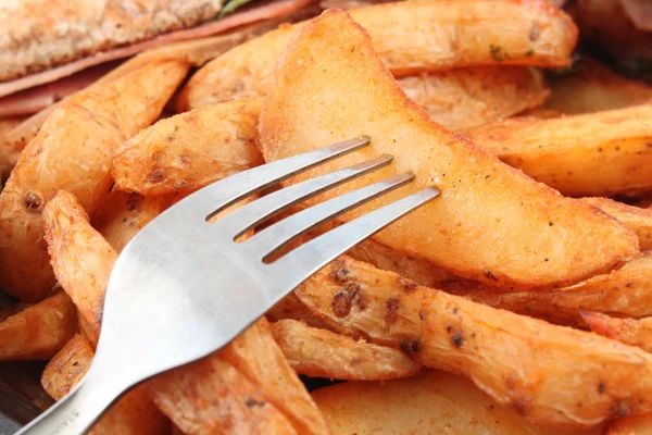 Potato wedges and fork — Stock Photo, Image