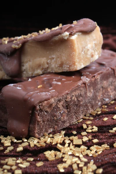 Chocolate, e bordo, ou fudge de caramelo em fundo marrom — Fotografia de Stock