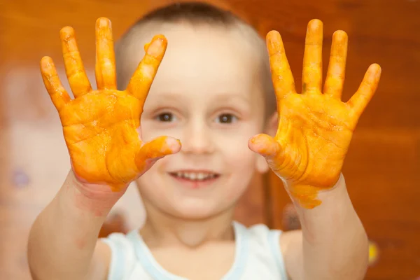 Ler pojke med sina händer i färg — Stockfoto