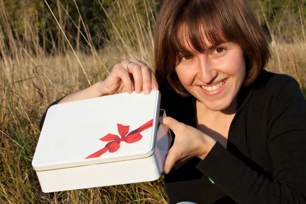 Улыбающаяся молодая женщина открыла белую коробку — стоковое фото