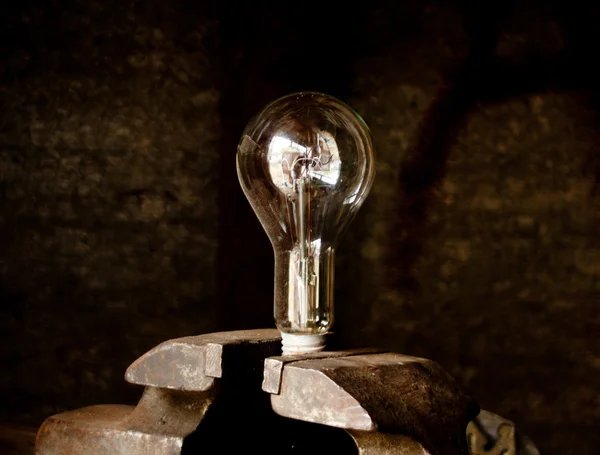Lightbulb held in a vise — Stock Photo, Image