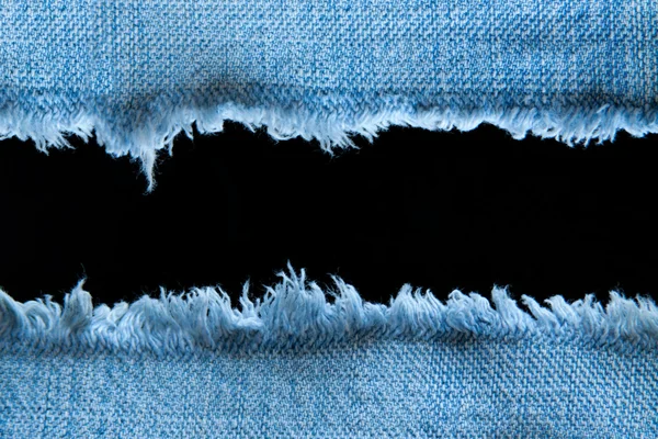 Разорванные синие джинсы с черным пространством — стоковое фото