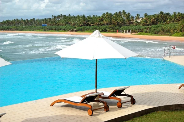 Лежаки у бассейна с видом на море, Бентота, Шри-Ланка — стоковое фото