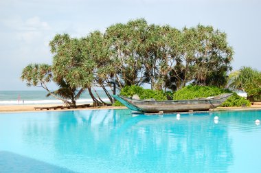 The swimming pool and old traditional boat as decoration in luxu clipart