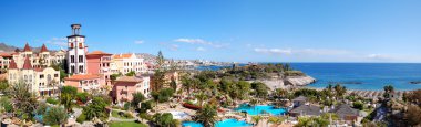 Panorama of luxury hotel and Playa de las Americas at background clipart