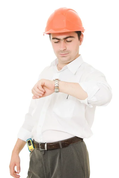 Empresario en casco mira su reloj . — Foto de Stock