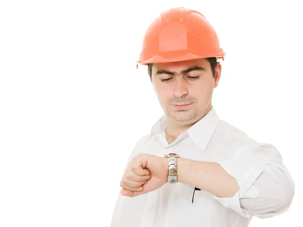 Podnikatel v helmě se dívá na hodinky. — Stock fotografie