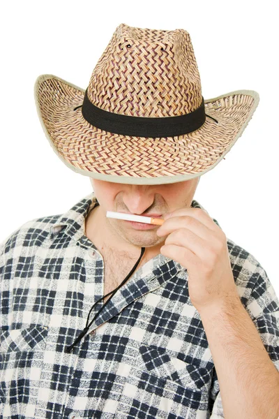Ковбой нюхает сигарету на белом фоне . — стоковое фото