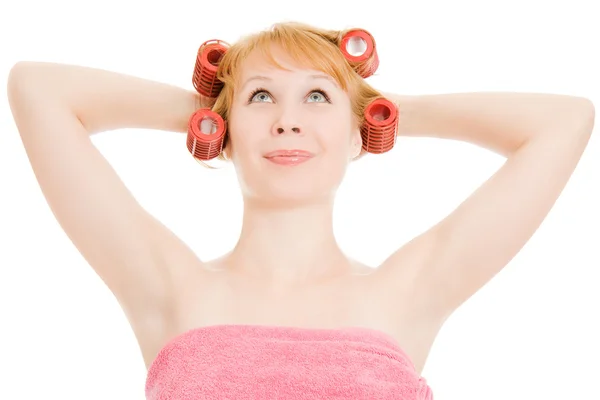 A woman in curlers looking up on white background. — Stock Photo, Image