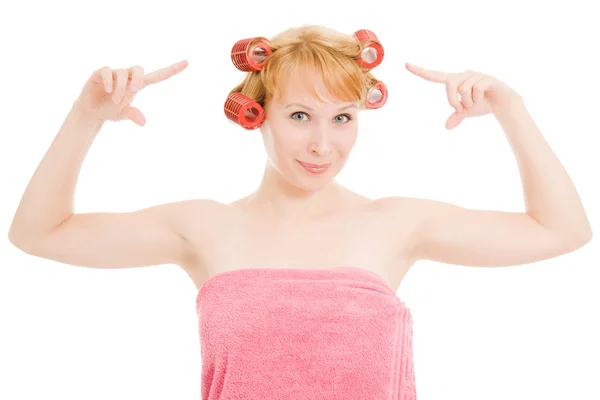 Woman in curlers hair indicates on a white background. — Stock Photo, Image