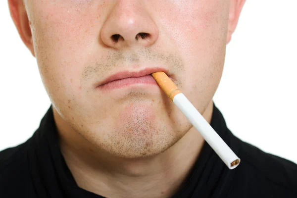 Een man met een sigaret in zijn mond. — Stockfoto